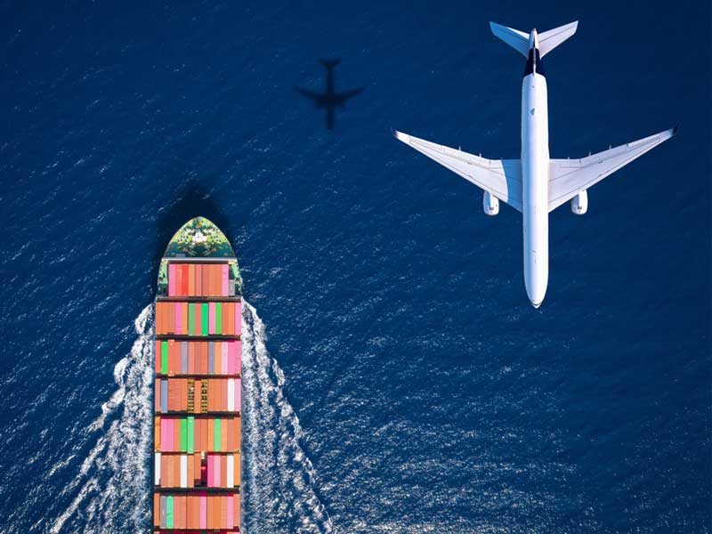 A n aerial view of a cargo ship and sailing on the ocean and a cargo plane flying